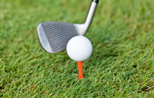 golfball und golfschläger tee auf grünem rasen nahaufnahme