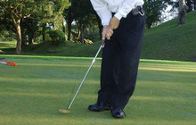 Lance Cpl. John F. SilwanusJohnny Kod, a salesman at the Korinza Shopping Mall, swings through a put on the 8th green during a charity tournament at Awase Meadows Golf Course.  The four-man-scramble golf tournament benefitted the Okinawa Child Development Center, a center for the mentally handicapped.